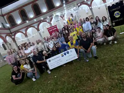 Foto di gruppo serale con l’assegno da 1.000 euro a Lampi Milano
