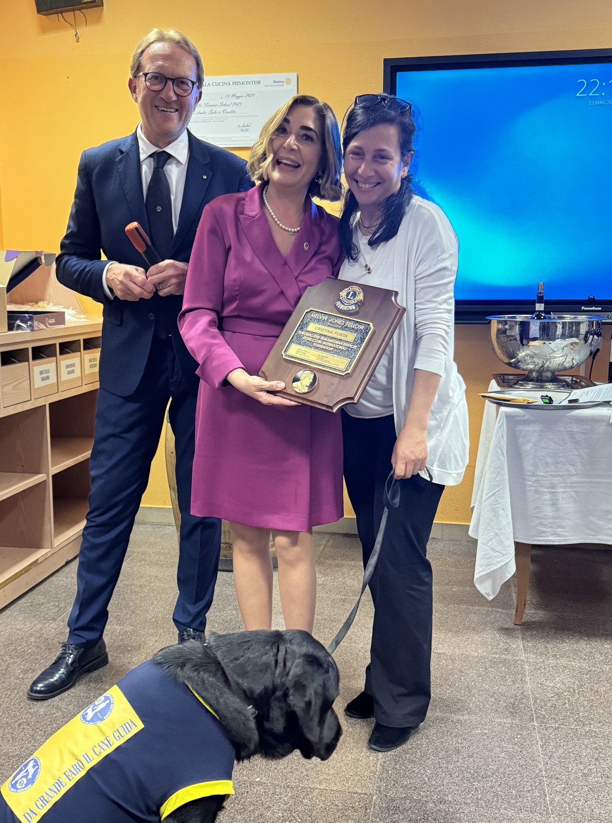 Cristina Porta riceve la targa Melvin Jones Fellowship, insieme a due colleghi Lions e a un cane guida